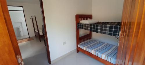 Cette chambre comprend 2 lits superposés et un miroir. dans l'établissement Maasai Villa Backpackers Home, à Fort Portal