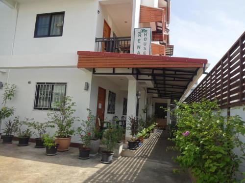 einen Innenhof eines Gebäudes mit Topfpflanzen in der Unterkunft Rena House Chiang Mai in Chiang Mai