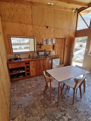 a kitchen and dining room with a table and chairs at Samay Lodge in Cochiguaz