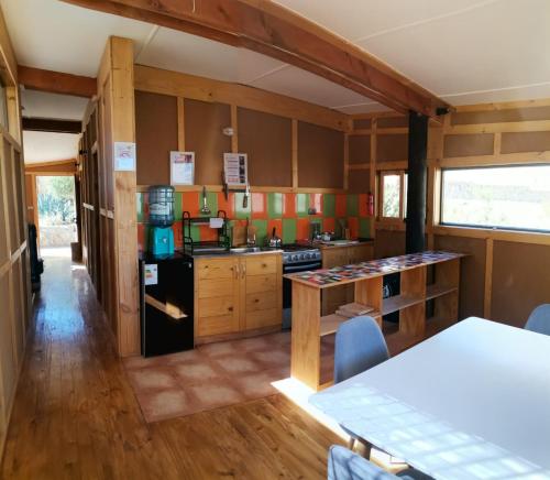 a kitchen with wooden cabinets and a black refrigerator at Samay Lodge in Cochiguaz