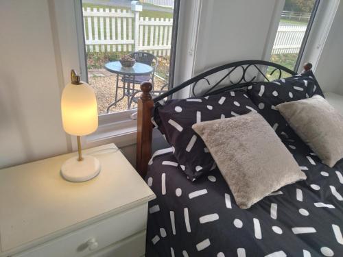 a bedroom with a bed with a lamp on a table at Self contained guest suite in Oatlands