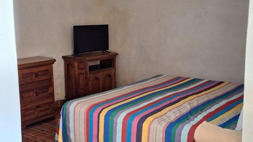 a bedroom with a bed and a television on a dresser at Hotel Colonial Taxco in Taxco de Alarcón