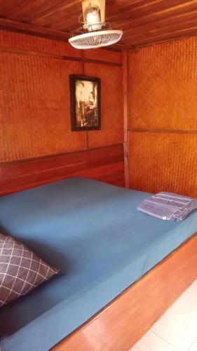 een bed in een kamer met een houten muur bij Bamboo Bungalow - Thong Nai Pan Yai in Thong Nai Pan Yai