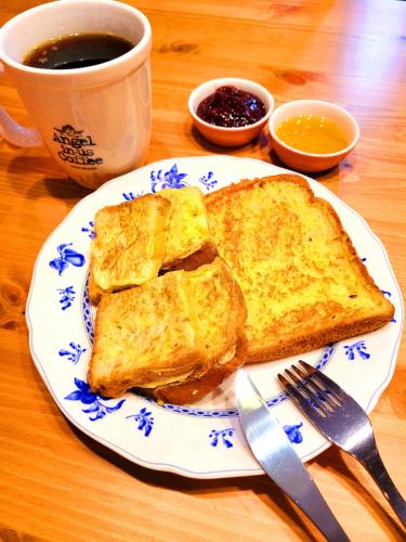 ein Teller mit zwei Toastscheiben und einer Tasse Kaffee in der Unterkunft Good Guesthouse in Seoul
