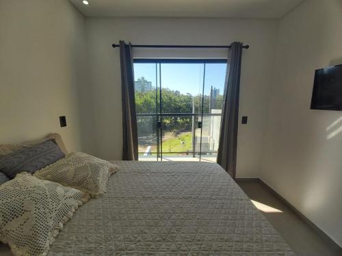 a bedroom with a bed and a large window at Sobrado da Renata no Centro de Foz in Foz do Iguaçu