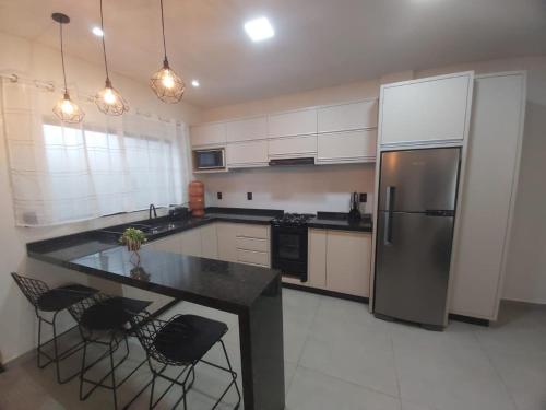 a kitchen with a stainless steel refrigerator and black counter tops at Sobrado da Renata no Centro de Foz in Foz do Iguaçu