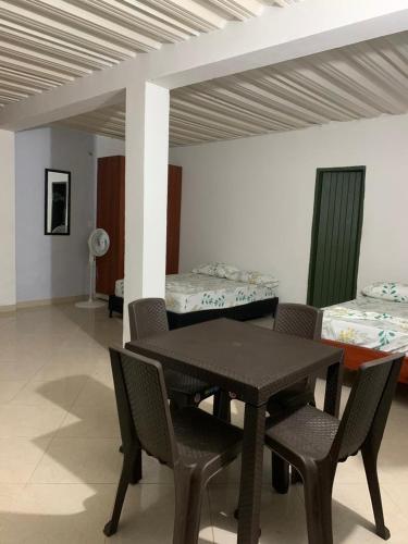 uma sala de jantar com uma mesa e cadeiras e 2 camas em APARTAESTUDIO DORADAL ANT em Puerto Triunfo