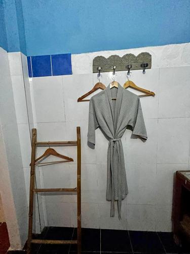 a dress is hanging on a wall with a skateboard at Beach House Cambodia in Koh Rong Sanloem