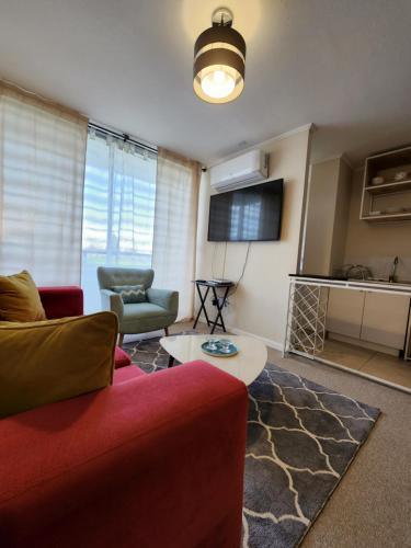 a living room with a red couch and a table at Condominio privado. Cómodo y central departamento nuevo in Talca