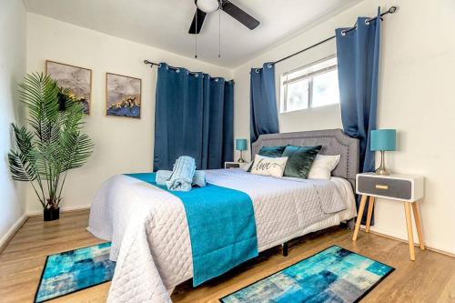 1 dormitorio con 1 cama con cortinas azules y 2 alfombras en 314 NEW 5BR Alamo River Walk Zoo SeaWorld SAT, en San Antonio