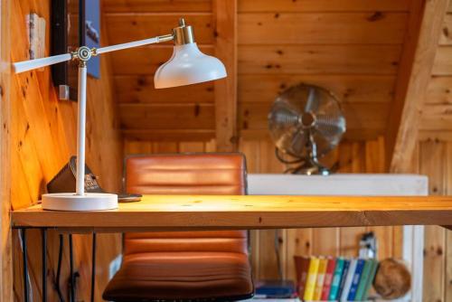 einen Schreibtisch mit einer Lampe und einem Stuhl in der Unterkunft Sugar Tree Cabin in Pigeon Forge