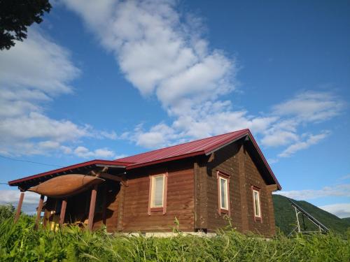 富良野市にあるログコテージ　be with natureの赤い屋根の小さな木造家屋