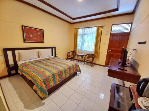 a bedroom with a bed and a desk and a television at Lembah Ciater Resort Managed by Sahid in Ciater