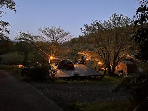 a group of tents in a field at night at ぼっちの森 in Minamiizu