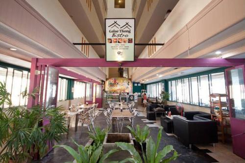 a lobby with tables and chairs in a building at Penthouse Galare Thong Tower - Stunning Views - Near Pool & Tennis in Chiang Mai