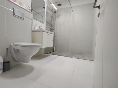 y baño blanco con ducha y aseo. en Apartament cu terasa Atelierul de Pizza Floresti Cluj, en Floreşti