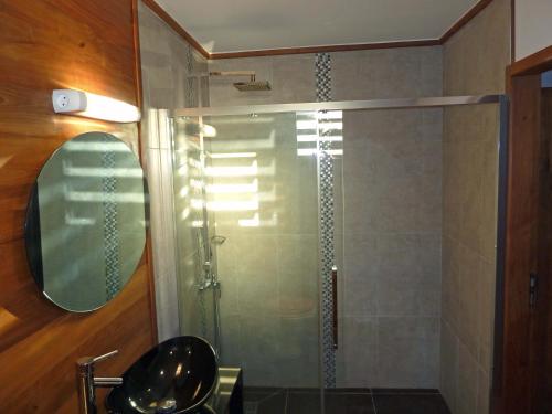 uma casa de banho com um chuveiro e uma porta de vidro em bambous-bungalows em Entre-Deux