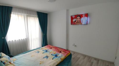 フロレシュティにあるApartament cu terasa Atelierul de Pizza Floresti Clujのベッドルーム1室(ベッド1台付)が備わります。壁に絵が飾られています。
