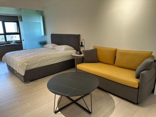 頭城的住宿－幸福M&M House-龜山日出溫泉景觀宅，一间卧室配有一张床、一张沙发和一张桌子