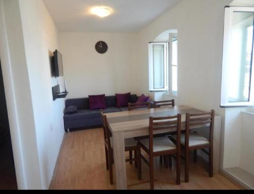 ein Wohnzimmer mit einem Tisch und einem Sofa in der Unterkunft Apartment Kova - 10 m from sea in Murter