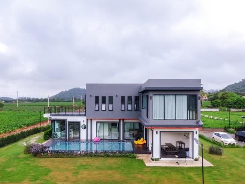 an aerial view of a house with a yard at Chacha Tyme Pool Villa Khaoyai in Wangkata