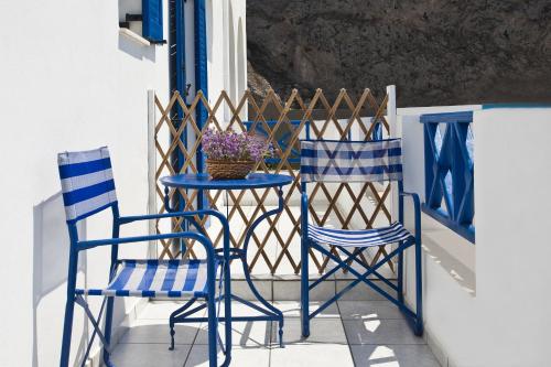 two blue chairs and a table on a balcony at Ancient Thera Studios in Perissa