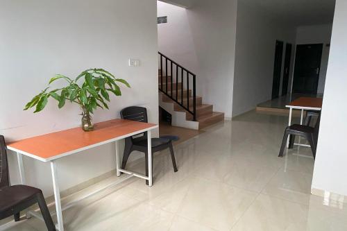 - un salon avec une table et une plante dans l'établissement OYO 92932 Guesthouse Marbella, à Nongsa