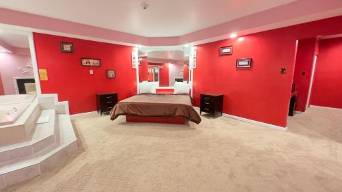 a bedroom with red walls and a bed and a sink at Inn of the Dove - Romantic Luxury Suites with Jacuzzi & Seasonal Fireplace at Harrisburg-Hershey-Philadelphia, PA in Harrisburg