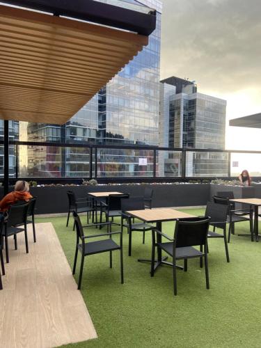 a cafeteria with tables and chairs and a view of a city at Exclusivo Apartastudio Zona Norte de Bogota in Bogotá