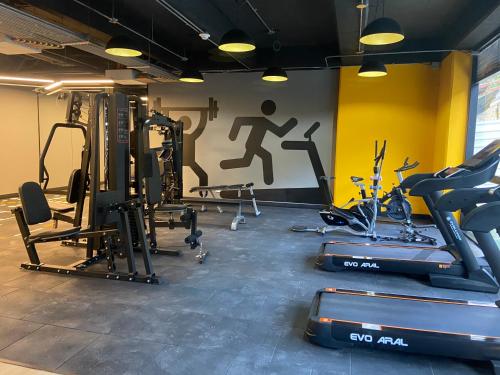 a gym with cardio equipment and a wall with a painting at Exclusivo Apartastudio Zona Norte de Bogota in Bogotá