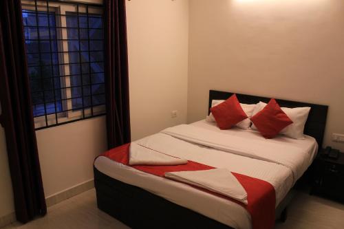 a bedroom with a bed with red and white pillows at S M RESIDENCY HOTEL in Bangalore