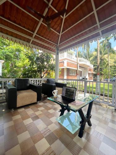 a living room with a laptop on a glass table at Sundeck Villa in Alibaug