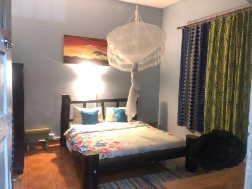 Schlafzimmer mit einem Bett und einem Kronleuchter in der Unterkunft Sarah’s place in Mbale