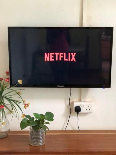einen TV an einer Wand mit einem Netflix-Schild drauf in der Unterkunft Sarah’s place in Mbale