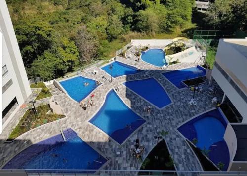 een uitzicht over een zwembad met blauw water bij Hotel Park Veredas Flat -Vista Piscinas Acesso ao Rio ao lado do Hot Park in Rio Quente