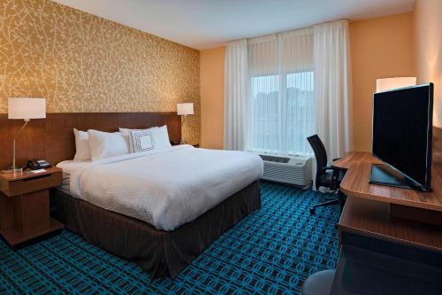 a hotel room with a bed and a desk and a television at Fairfield Inn & Suites by Marriott Atlanta Peachtree City in Peachtree City