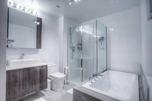 uma casa de banho com um chuveiro, um WC e um lavatório. em 2 bedroom Condo in the heart of the city Montreal em Montreal
