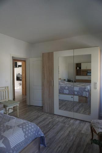 a bedroom with a large glass closet and a bed at Dat Wittsche Hus - Ferienwohnung an der Nordsee in Wilhelmshaven