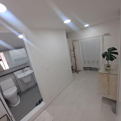 a white bathroom with a toilet and a sink at Dongpirang Private Pension #jungangmarket #petfriendly in Tongyeong