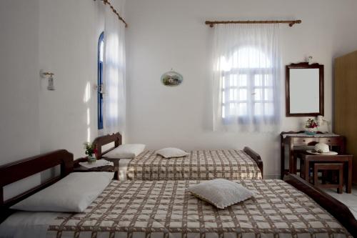 a bedroom with two beds and a window at Ancient Thera Studios in Perissa