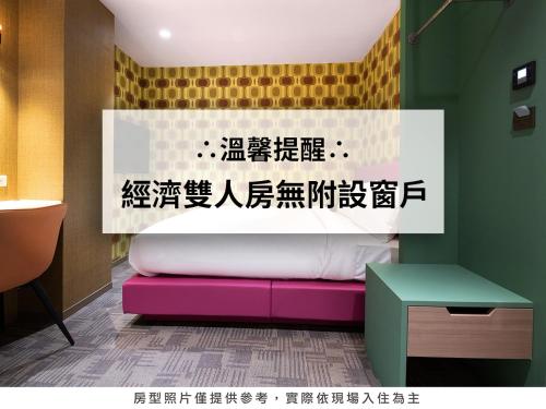 Cama en habitación con escritura en la pared en Royal Group Hotel Xiong Zhong Branch en Kaohsiung