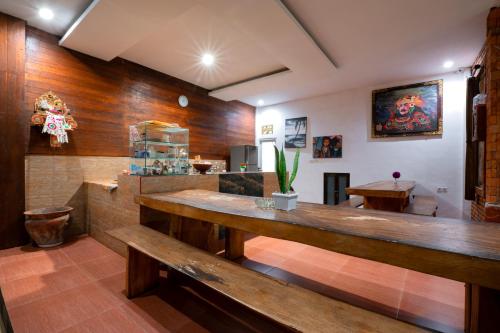 a restaurant with wooden walls and a counter with benches at Asri Guesthouse in Canggu