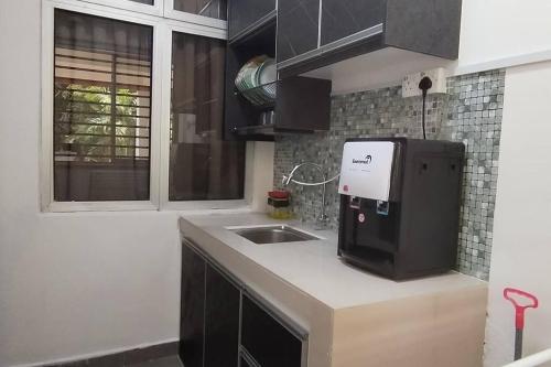 a kitchen with a sink and a microwave on a counter at Saga Laguna Condo Homestay in Port Dickson