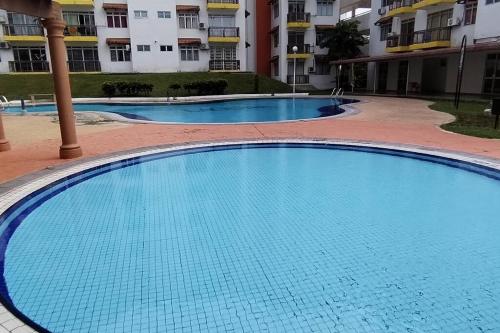 a large swimming pool in front of a building at Saga Laguna Condo Homestay in Port Dickson