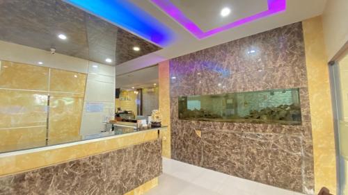 a bathroom with brown tile walls and a purple ceiling at Cemara Asri INN in Pulauberayan Dadap