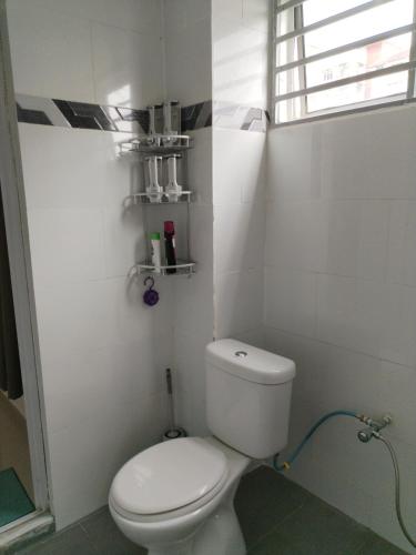 a bathroom with a white toilet and a window at Saga Laguna Condo Homestay in Port Dickson