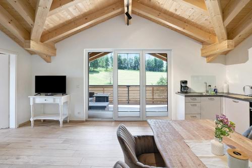 a kitchen and living room with wooden ceilings and a table at Ferienwohnung Schwaiger Almblick in Bad Tölz