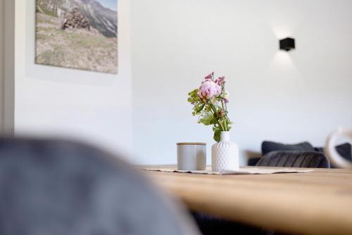 a table with a vase with a flower in it at Ferienwohnung Schwaiger Almblick in Bad Tölz
