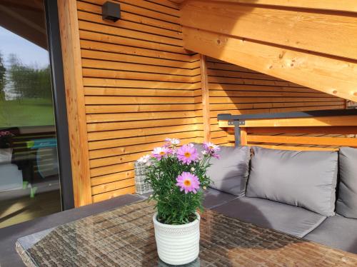 a vase of flowers on a table with a couch at Ferienwohnung Schwaiger Almblick in Bad Tölz