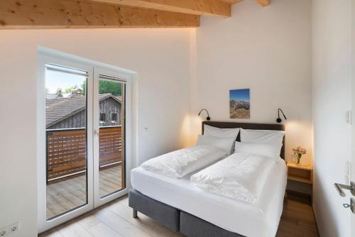 een slaapkamer met een bed en een groot raam bij Ferienwohnung Wendelsteinblick in Bad Tölz